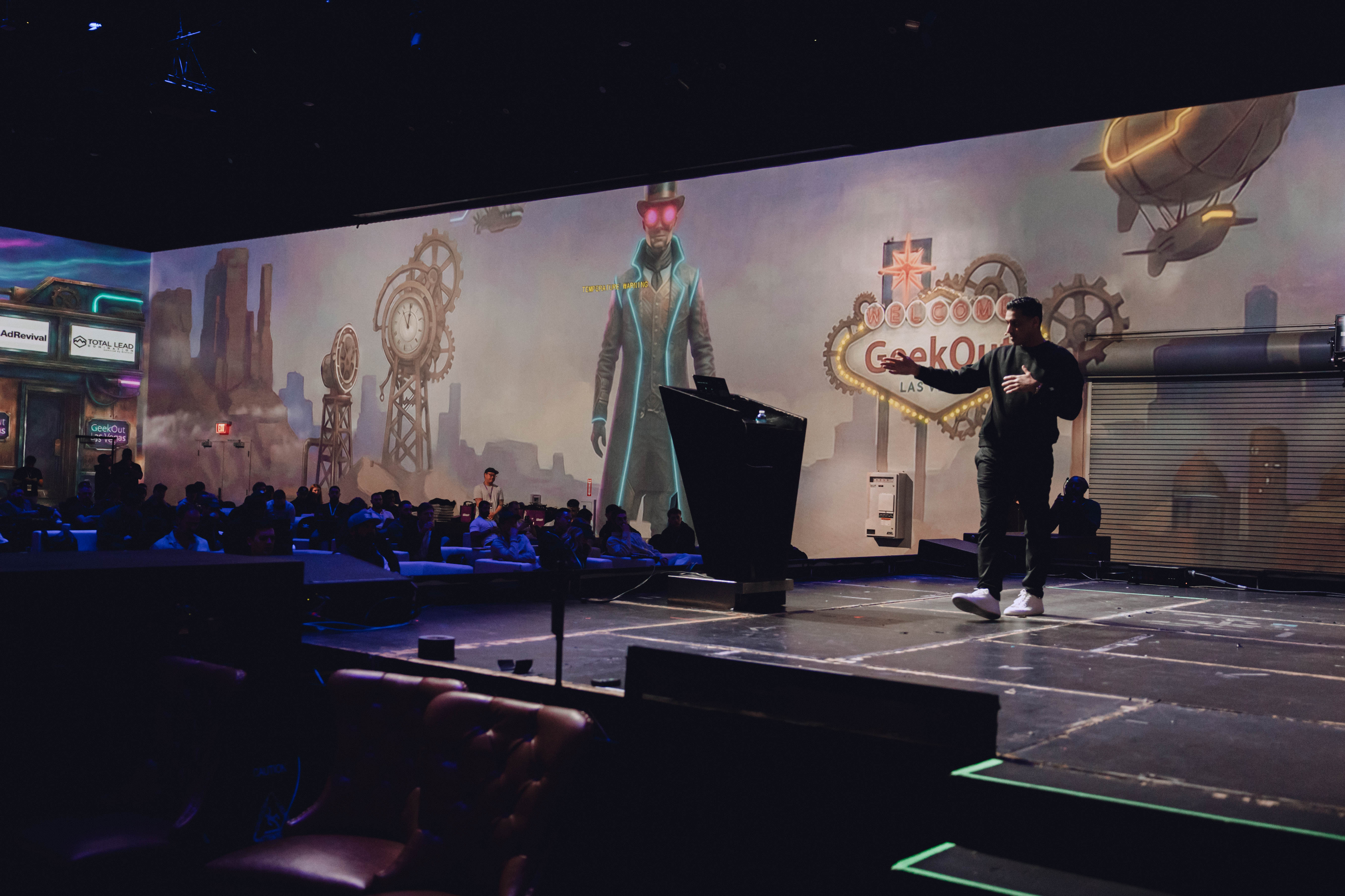 Samar Hussain on stage at GeekOut Las Vegas with audience